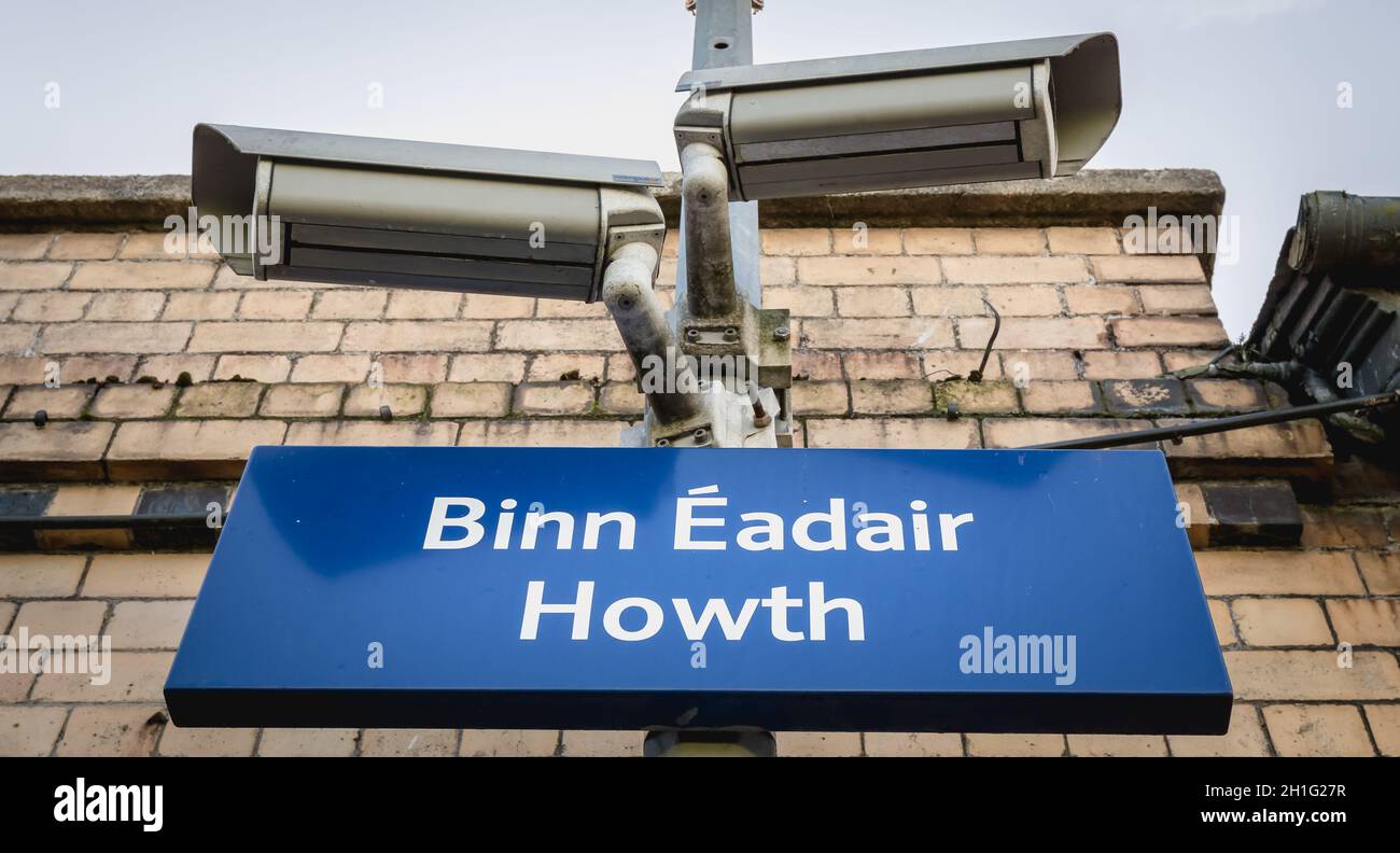 Howth, Irlanda - 15 febbraio 2019: Cartelli blu che mostrano la stazione ferroviaria di Howth (Bin Eadair) con telecamere di sorveglianza a piattaforma in un giorno invernale Foto Stock