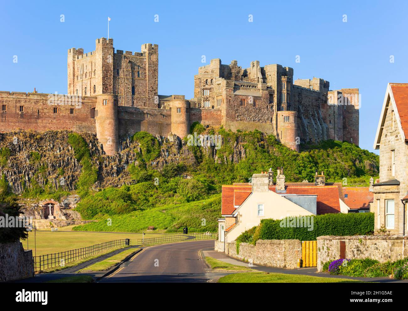 Castello di Bambburgh Northumberland Bambburgh Inghilterra guardando le pareti del Castello di Bambburgh e il Villaggio di Bambburgh case di Bambburgh Northumberland Inghilterra UK GB Foto Stock