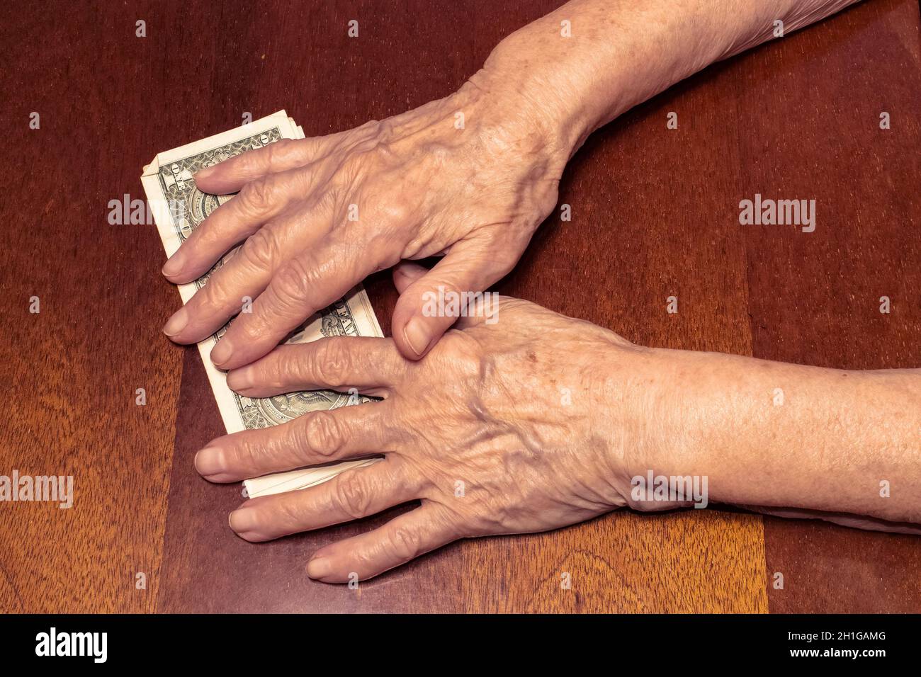 Una banconota nelle mani di una donna anziana. 5 l'irivnia Ucraina come concetto di povertà Foto Stock