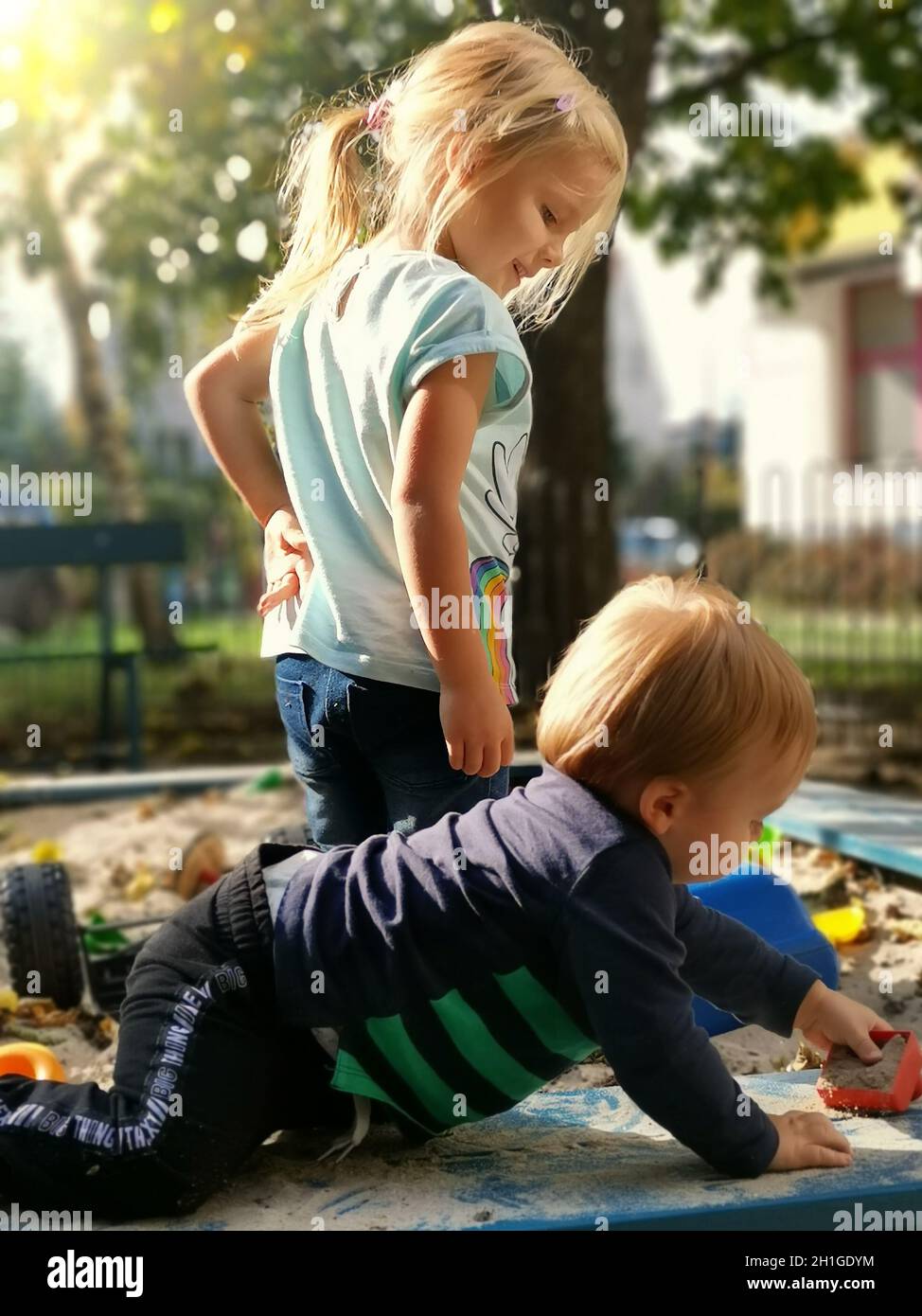 Sorella e fratello che giocano con la sabbia. Adorabile famiglia di bambini in sandbox sul parco giochi. Felicità di giocare insieme fuori. Fratello di fratello Foto Stock