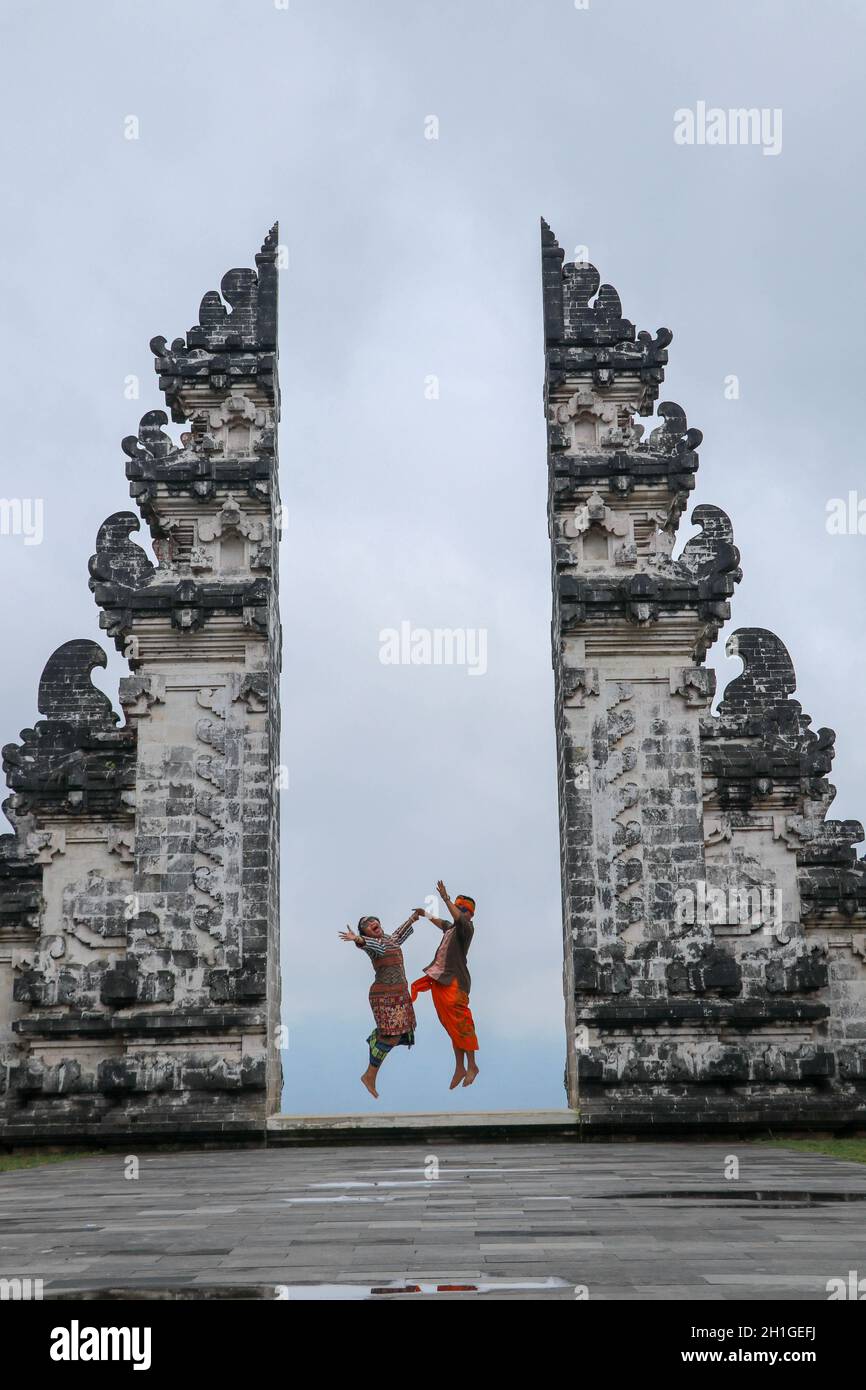 Felice giovane coppia che salta nelle porte del tempio del cielo. Perfetto concetto di luna di miele. Tempio Lempuyang Luhur a Bali, Indonesia. Foto Stock