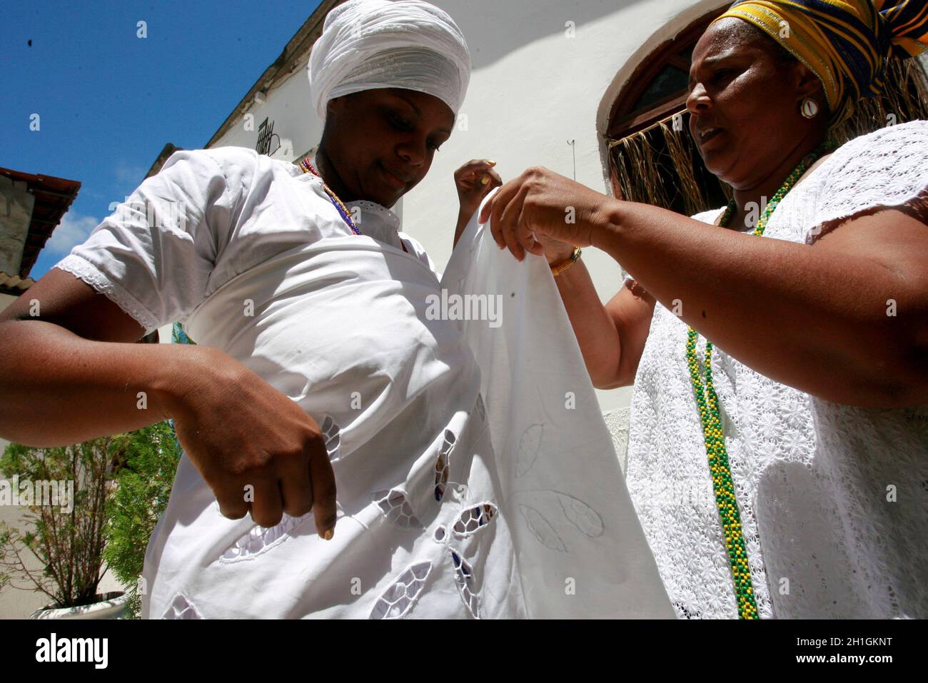 salvador, bahia / brasile - 12 febbraio 2015: Madre di santi da Candomble fa vestiti in un membro della religione in un terreiro candomble nel ci Foto Stock