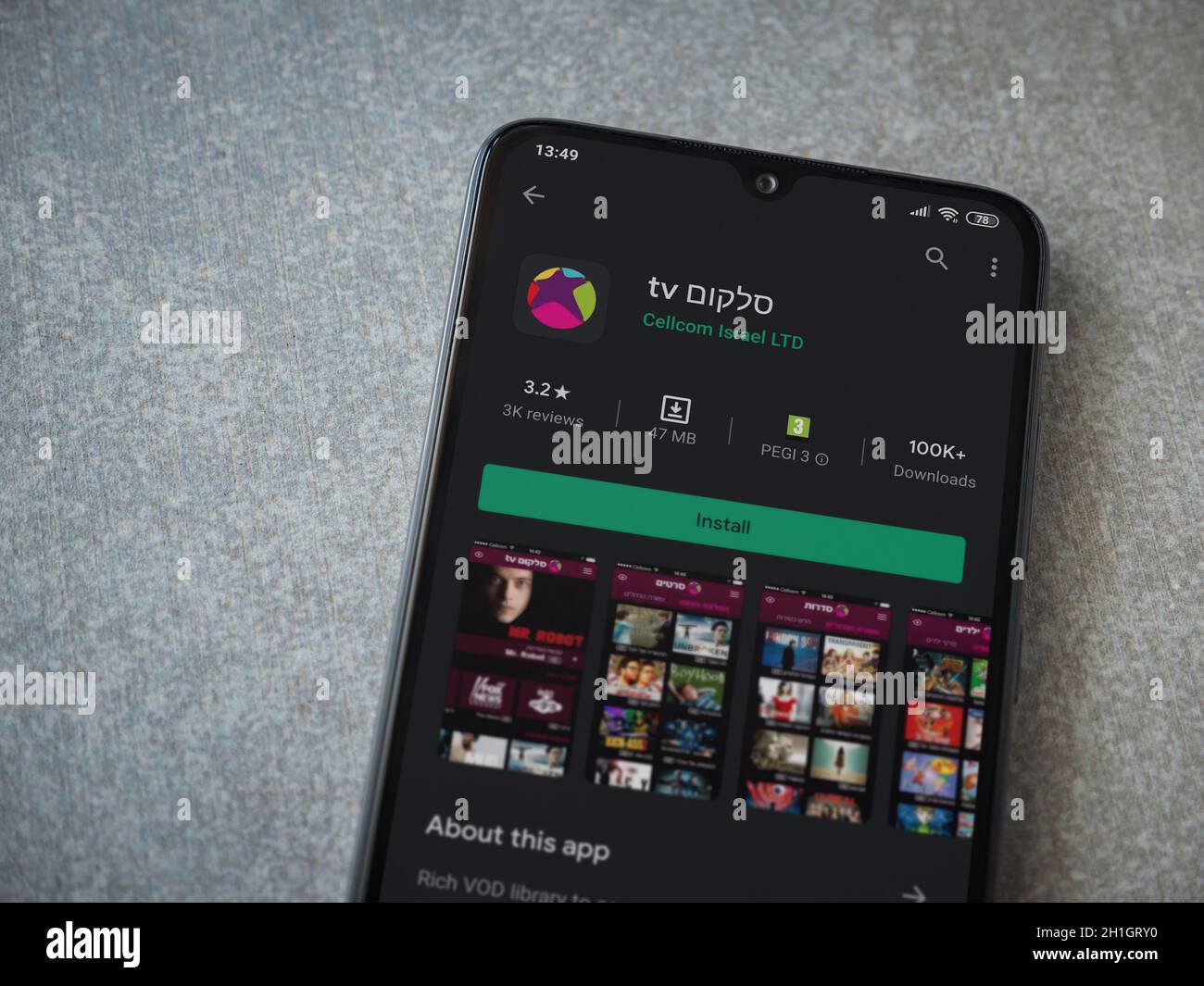 LOD, Israele - 8 luglio 2020: L'app Cellcom TV riproduce la pagina del negozio sul display di uno smartphone nero su sfondo in ceramica. Vista dall'alto in piano Foto Stock