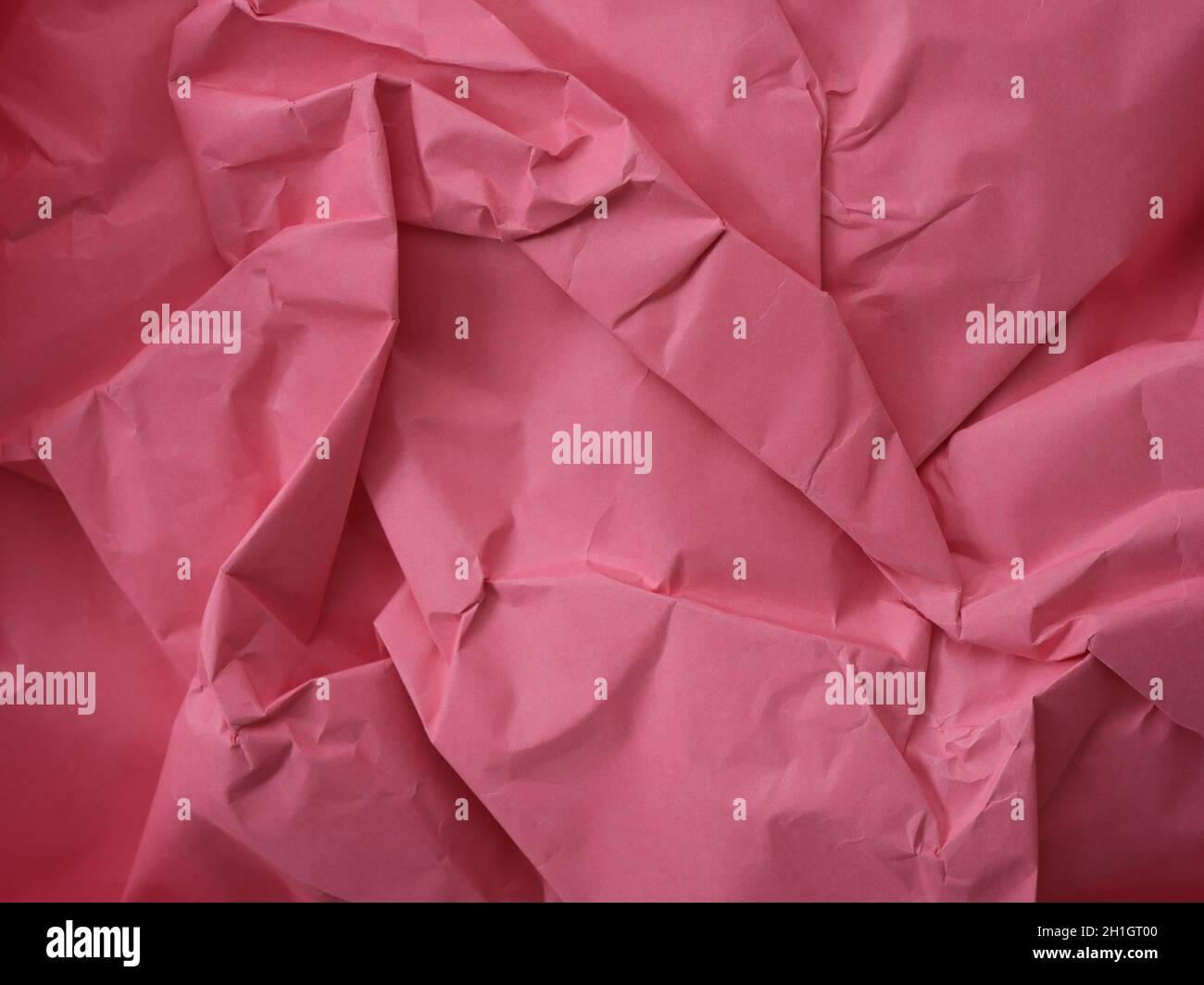 Uno sfondo di carta rosa stropicciato. Primo piano. Foto Stock