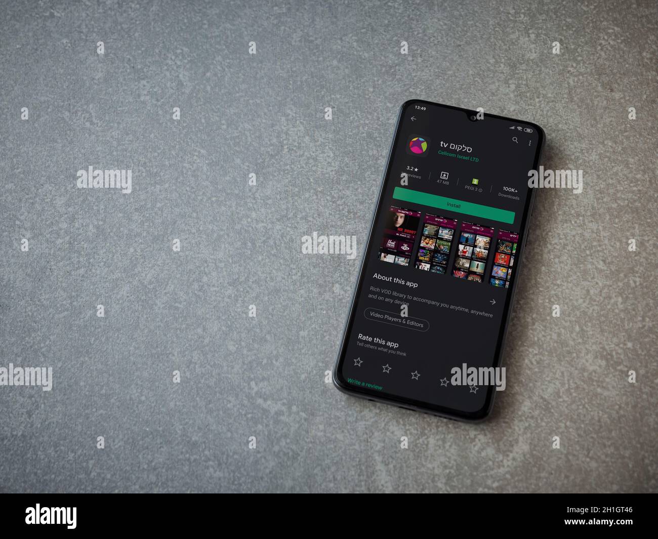 LOD, Israele - 8 luglio 2020: L'app Cellcom TV riproduce la pagina del negozio sul display di uno smartphone nero su sfondo in ceramica. Vista dall'alto in piano Foto Stock