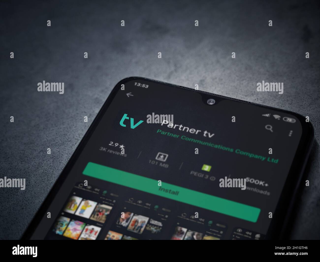 LOD, Israele - 8 luglio 2020: App partner tv play store page sul display di uno smartphone nero su sfondo di marmo scuro in pietra. Vista dall'alto piatta Foto Stock
