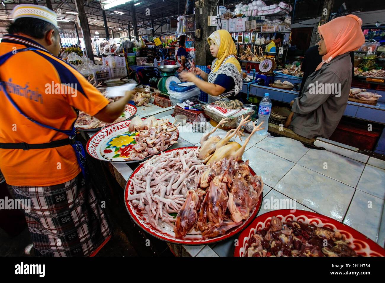 Khao Lak, Tailandia - 22 Febbraio 2016: donna sconosciuta acquisti freschi a base di carne di pollo dal commerciante locale sul mercato. Cucina tailandese è rinomata per i suoi gustosi Foto Stock