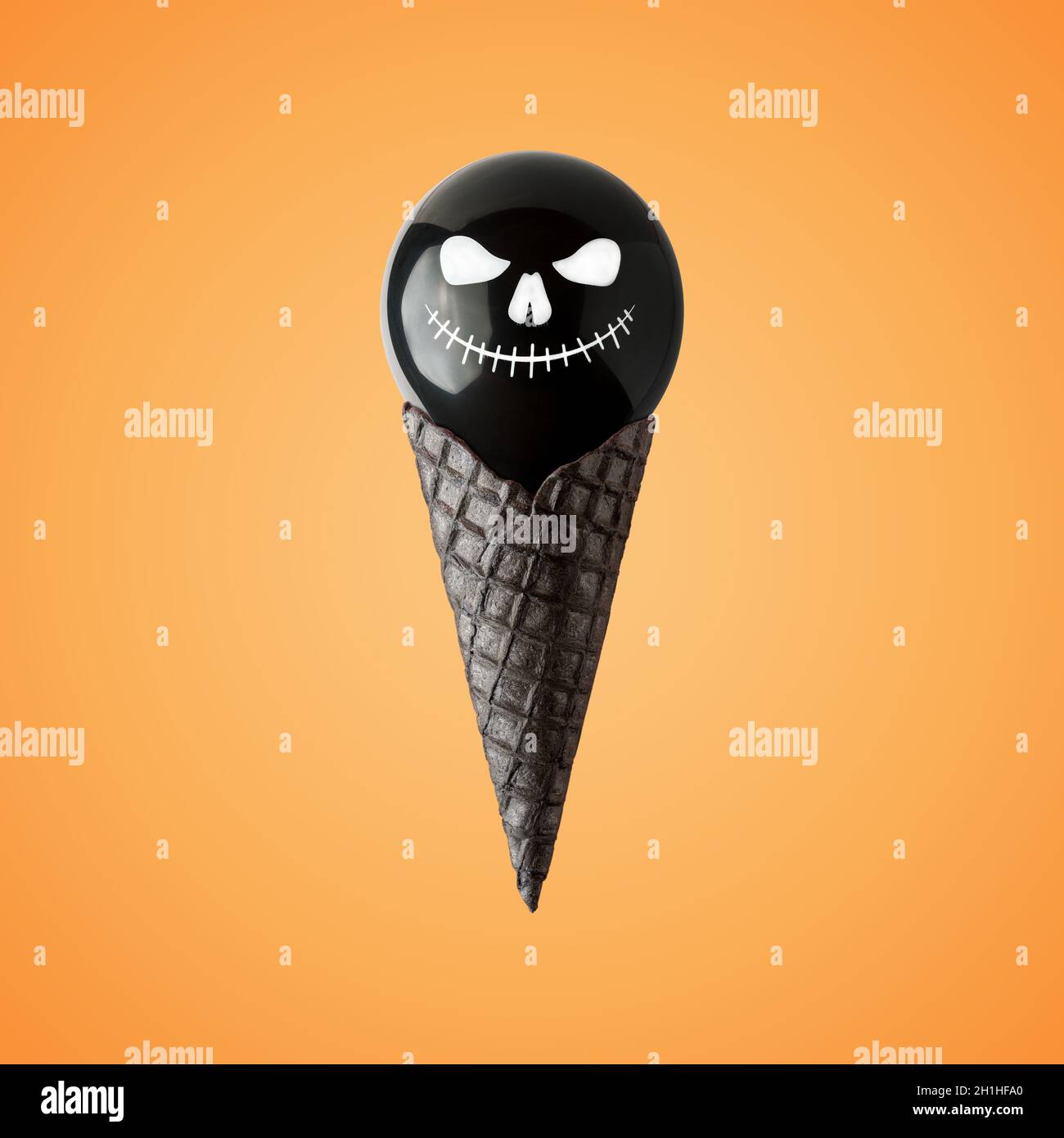 Palloncino di Halloween con cono gelato su sfondo luminoso. Minimo concetto di vacanza. Foto Stock