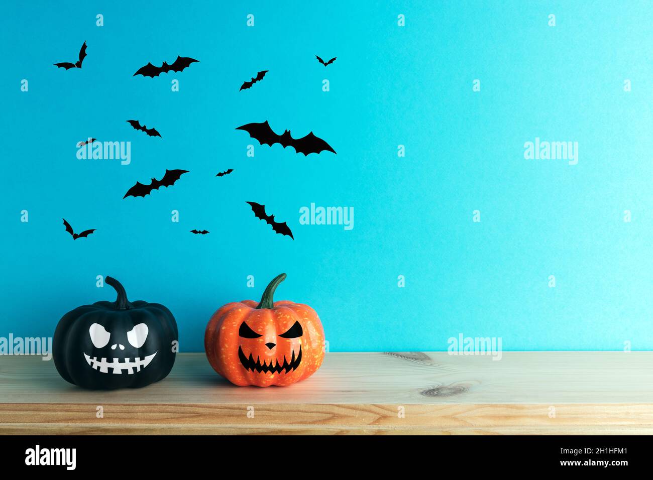 Decorazioni in zucca di Halloween con volti divertenti. Concetto minimo creativo di Halloween. Foto Stock