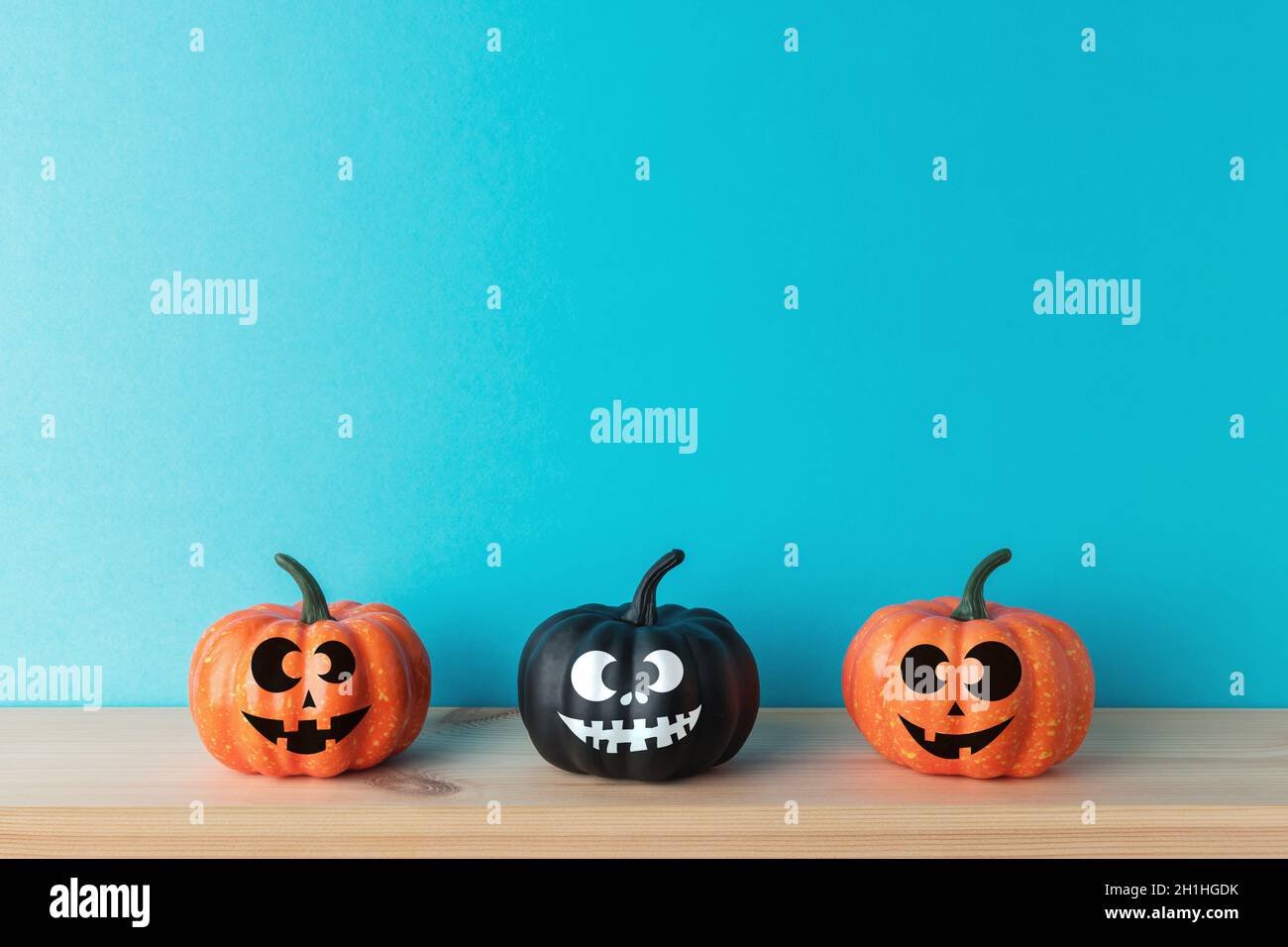 Decorazioni in zucca di Halloween con volti divertenti. Concetto minimo creativo di Halloween. Foto Stock