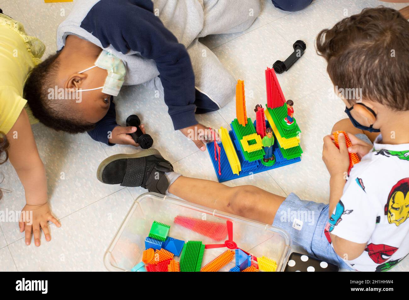 Istruzione Preschool 3-4 anni due ragazzi che giocano insieme costruendo con blocchi di plastica colorati di collegamento Foto Stock