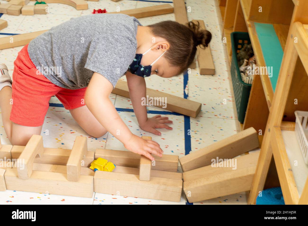 Istruzione Preschool 4-5 anni ragazzo giocando da solo, costruendo con blocchi di legno Foto Stock