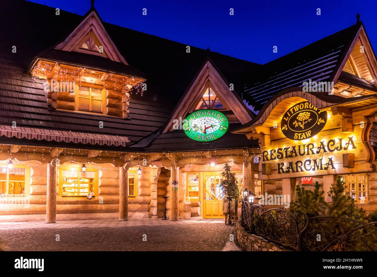 Bialka Tatrzanska, Polonia, marzo 2019 Ristorante tradizionale polacco in legno di notte. Popolare villaggio di sport invernali sui Monti Tatra Foto Stock