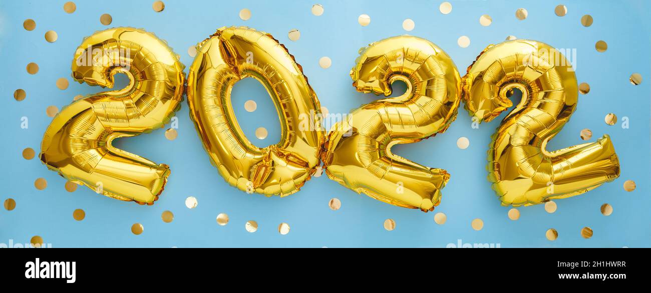 palloncini d'oro da 2022 anni con confetti su sfondo blu. Felice Capodanno 2022 vigilia di festa Foto Stock