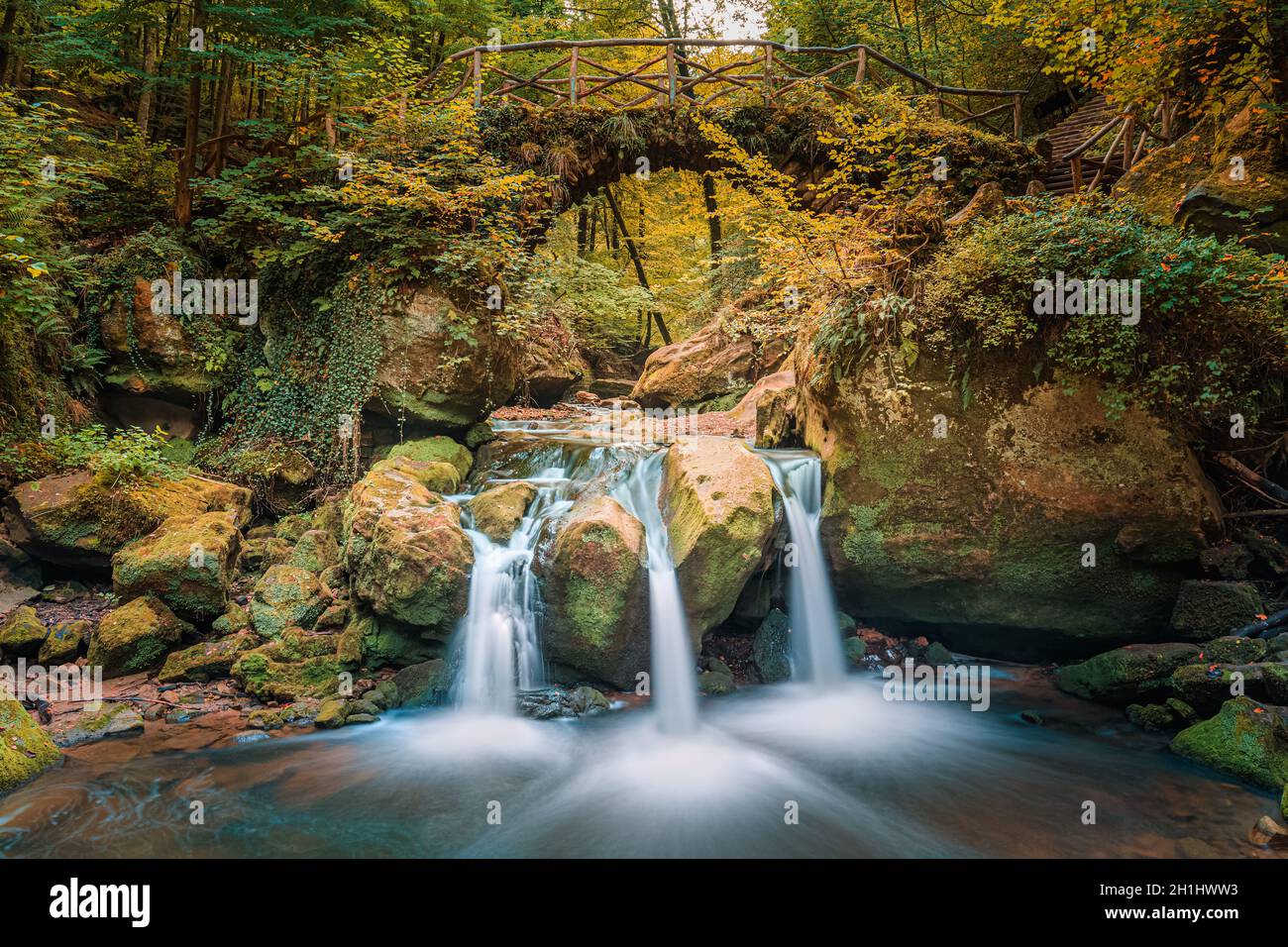 Cascata di Schiessentümpel / Schéissendëmpel. Il Schiessentümpel è una piccola e pittoresca cascata nel Black Ernz. Con il ponte di pietra arty e t Foto Stock