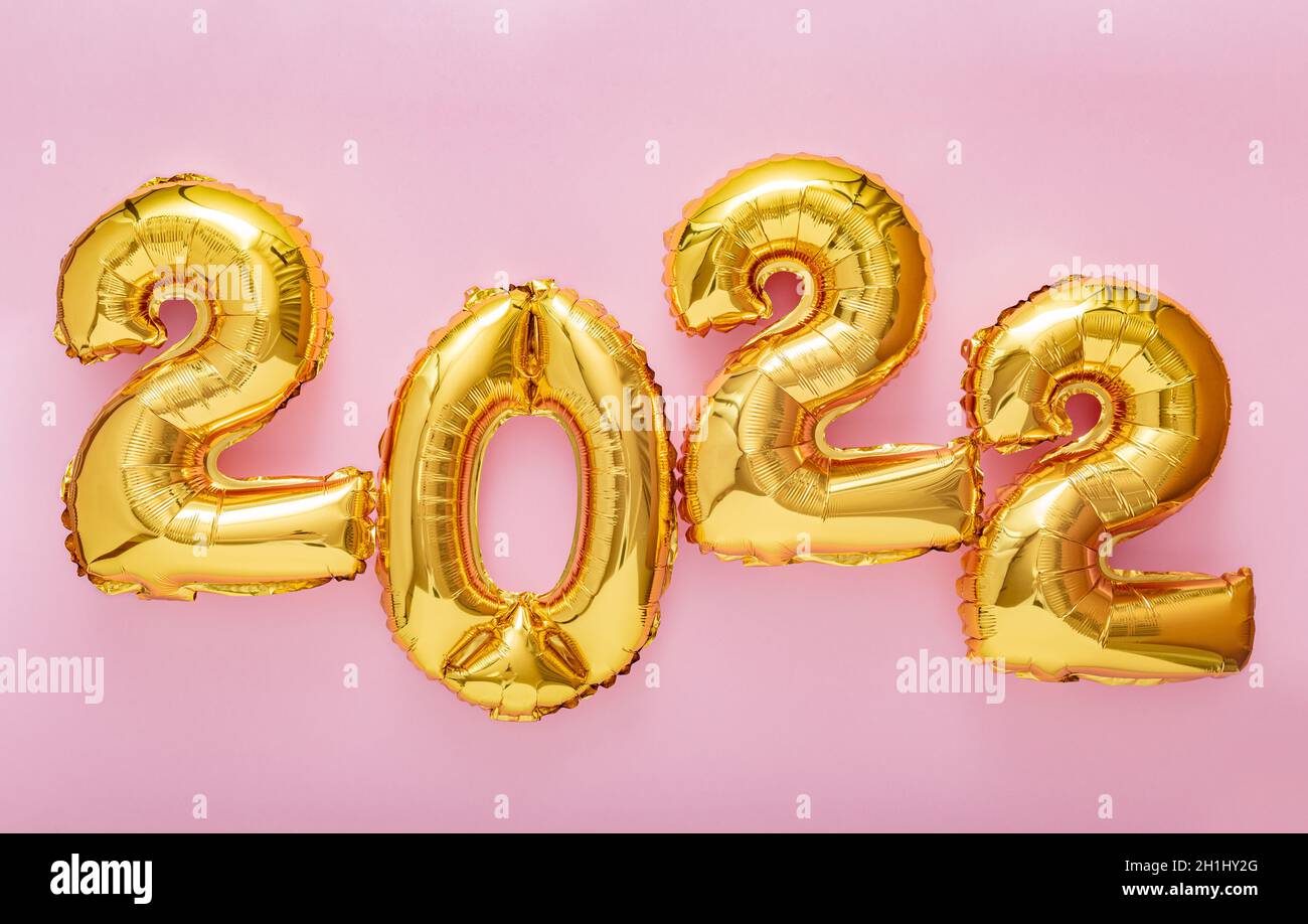 2022 palloncini d'oro su sfondo rosa. Felice anno nuovo 2022 lettere festa della vigilia. Buon banner di Natale Foto Stock