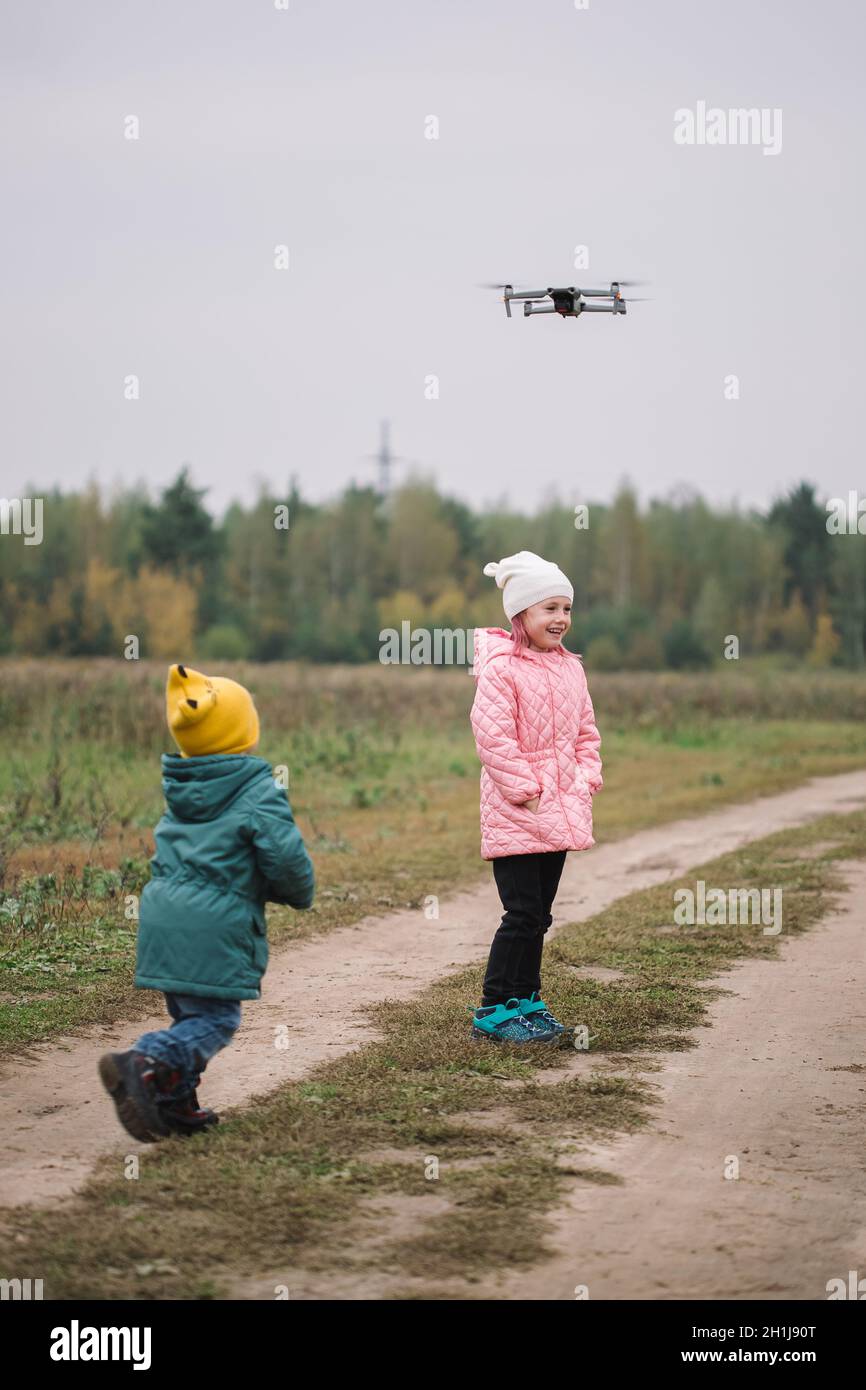 I bambini felici che giocano con il drone in autunno sul campo. Foto Stock