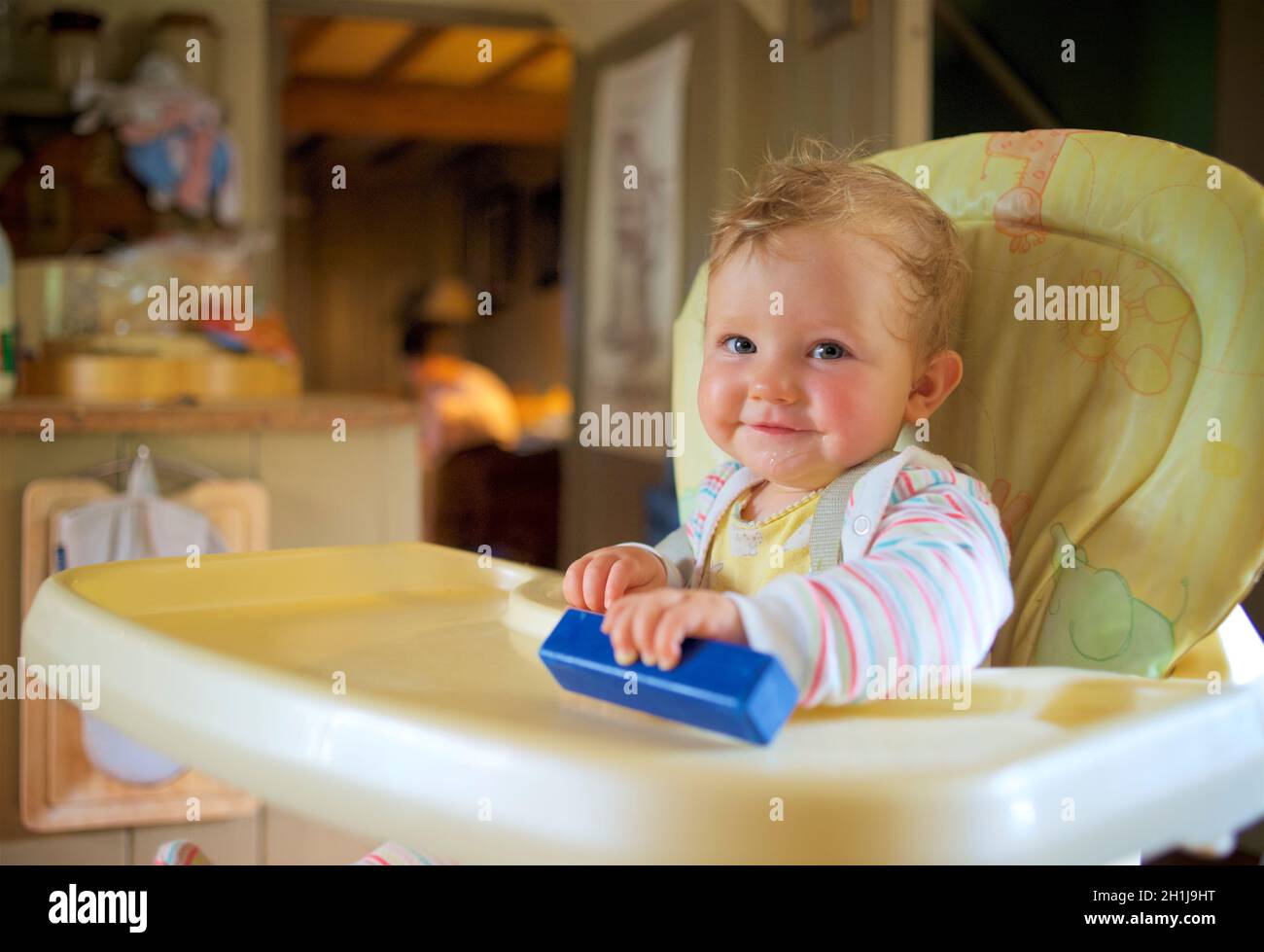 Faccia del bambino, grinning da una sedia alta e pronto per alimento. Modello rilasciato. Foto Stock