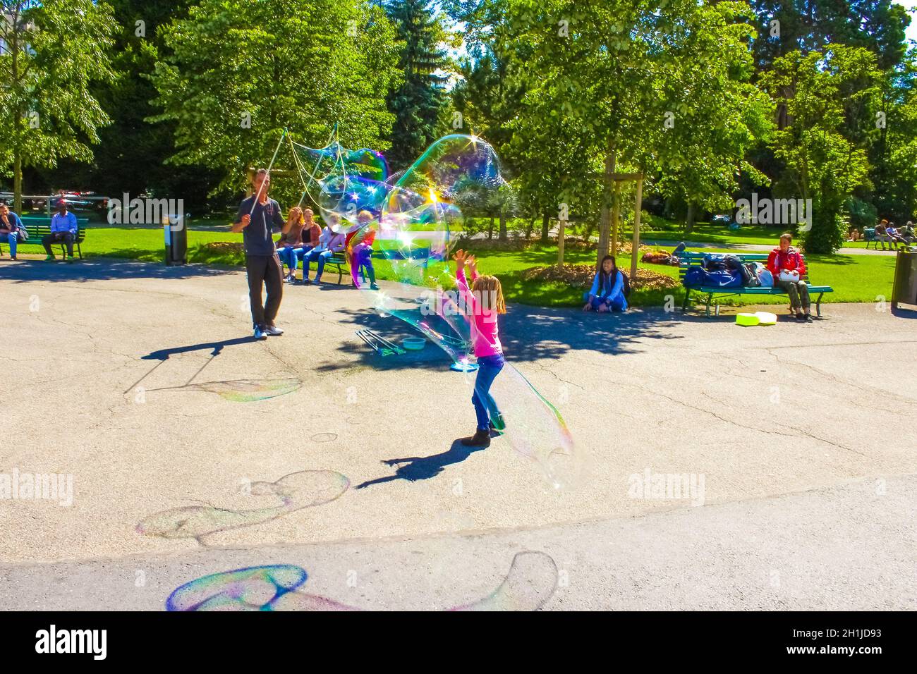 Ginevra, Svizzera - 17 giugno 2016: I bambini e le bolle di sapone attrarre nel parco della città vecchia di Ginevra, Svizzera, il 28 luglio 2010. IT Foto Stock