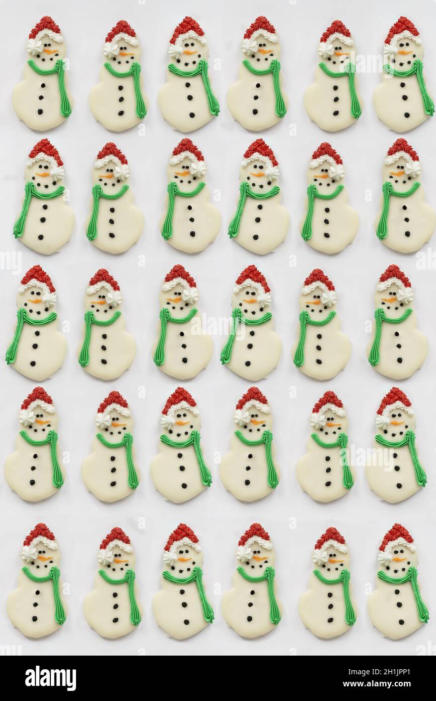 Biscotti ghiacciati di Natale o di Snowman con naso di carota, cappello di Santa e sciarpa. Gli snowmen hanno sparato dalla posizione piana o dall'alto della vista. Foto Stock