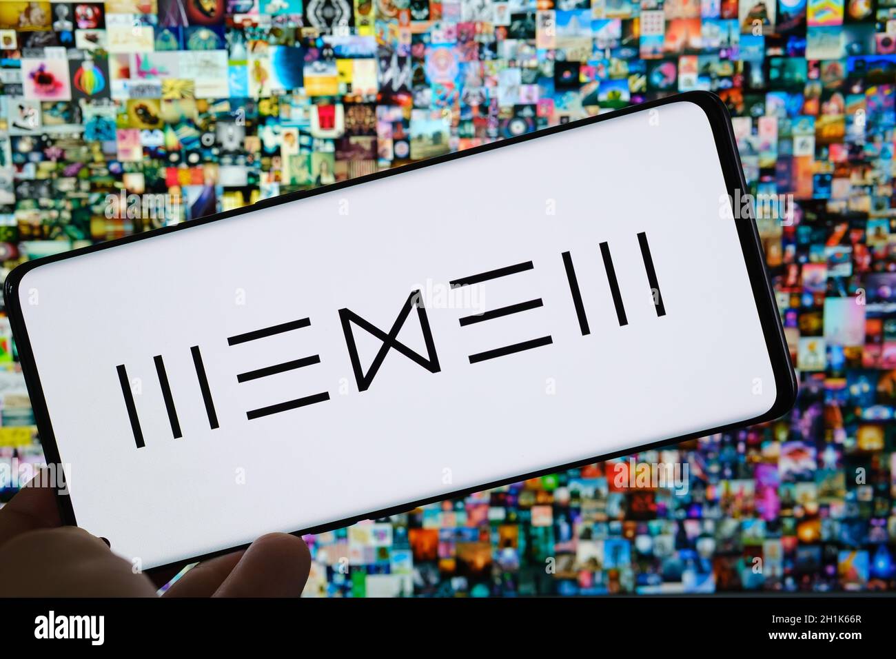 Il logo della piattaforma Beeple WENEW dell'artista digitale visto sullo smartphone e il suo collage di arte digitale NFT "Everydays the First 5000 Days" su sfondo sfocato. Foto Stock