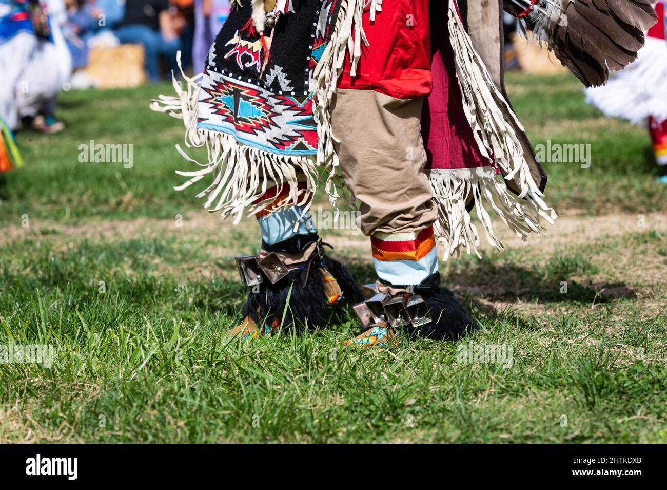 Foto di caviglie e coperta disegnata come parte di una regalia del ballerino dei nativi americani in un evento pubblico di pow wow. Foto Stock