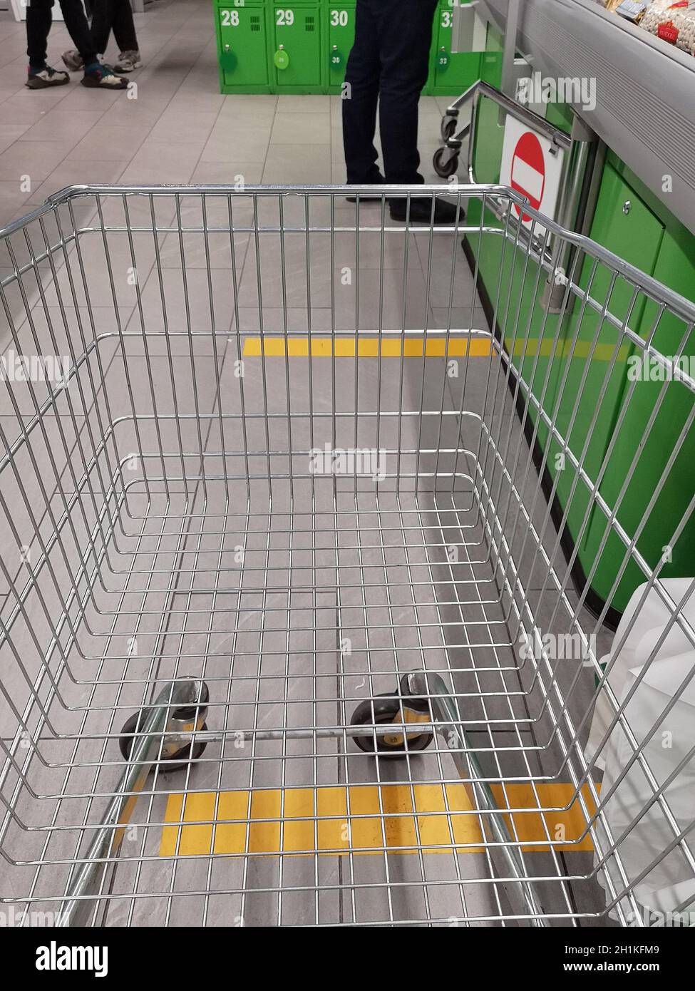 Distanza sociale. Marcatura con linee gialle in un supermercato per mantenere la distanza in quarantena. Marcature di distanza, segni sul pavimento in un dr Foto Stock