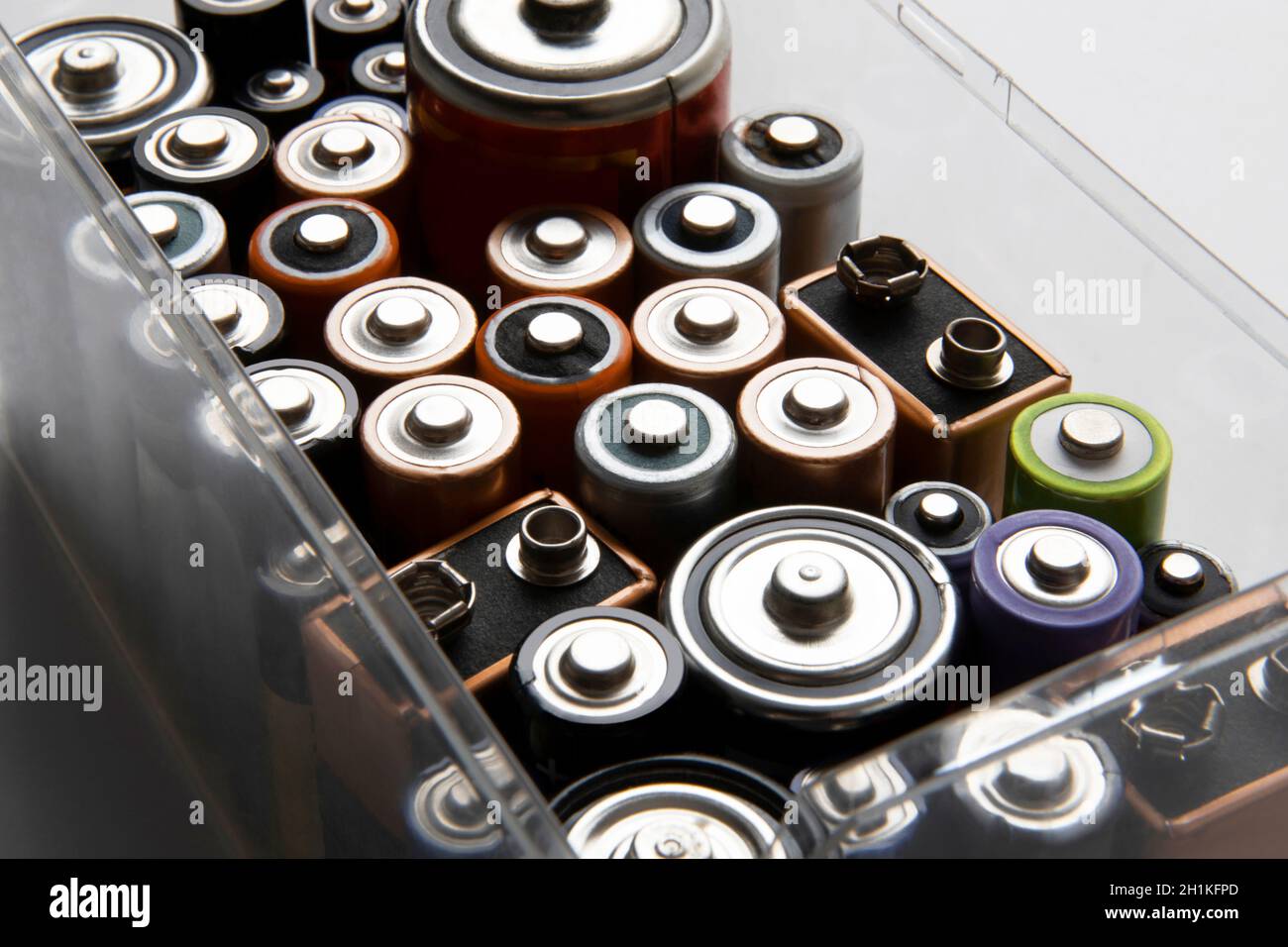 Raccolta di batterie alcaline di varie dimensioni in contenitore di plastica. Foto Stock