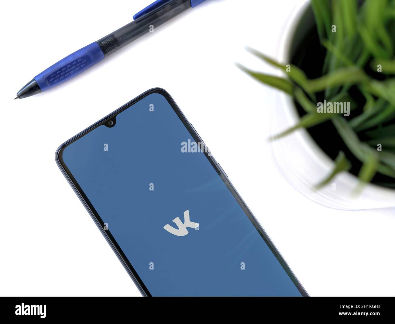 LOD, Israele - 8 luglio 2020: Spazio di lavoro moderno e minimalista per l'ufficio con smartphone nero con schermo di lancio dell'app VK con logo su sfondo bianco. T Foto Stock