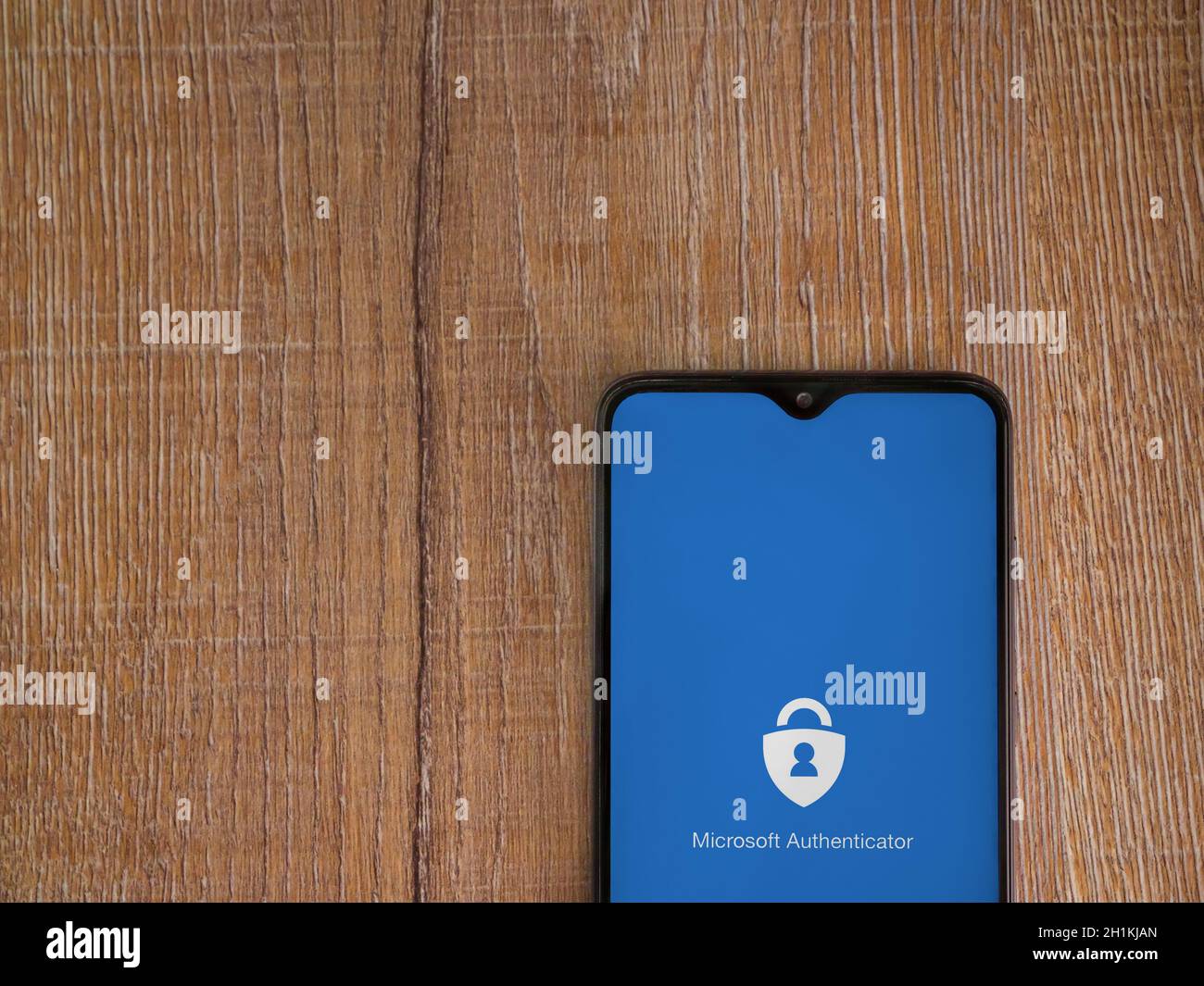 LOD, Israele - 8 luglio 2020: Schermata di avvio dell'applicazione Microsoft Authenticator con logo sul display di uno smartphone nero su sfondo in legno. In alto Foto Stock