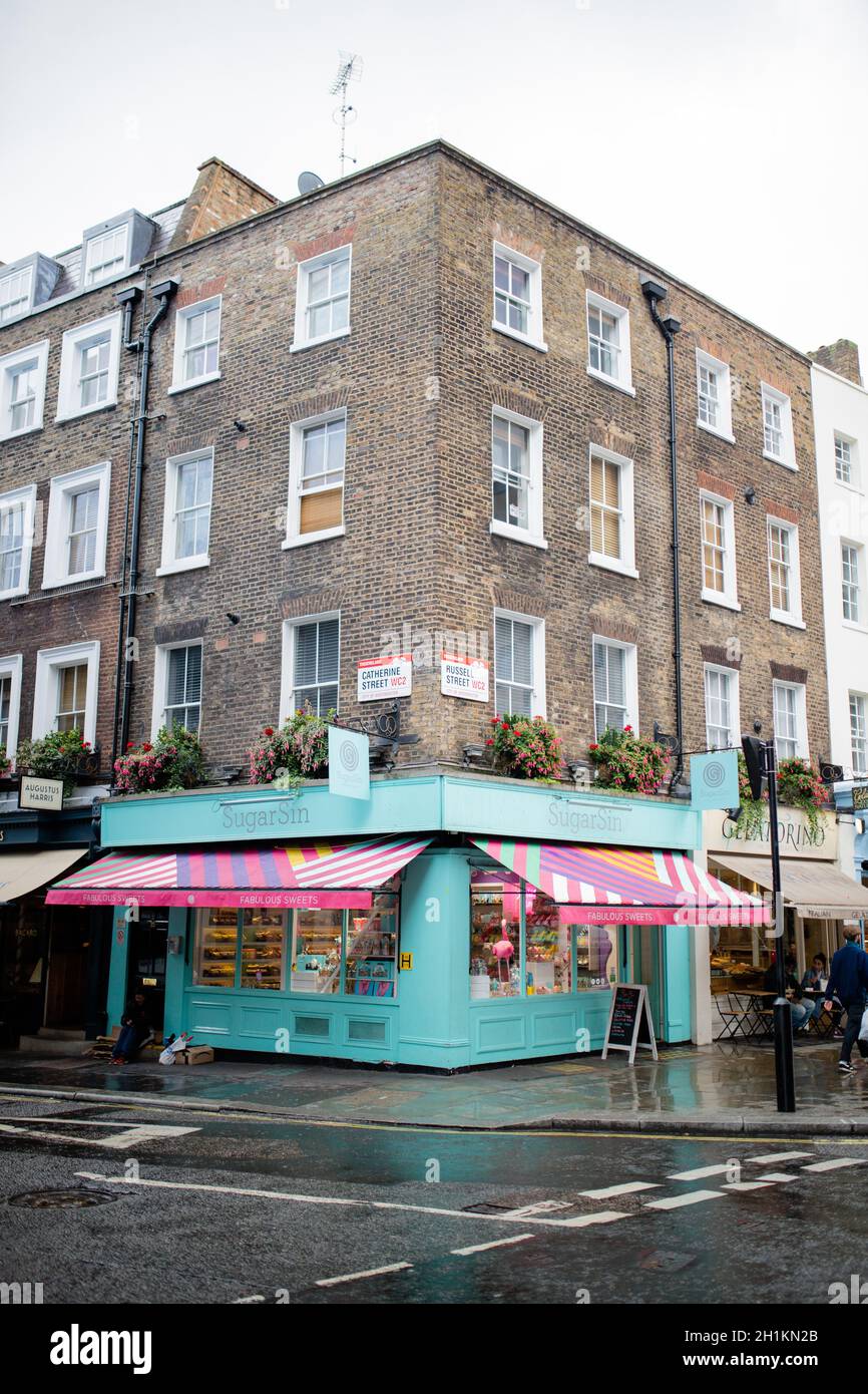 Londra, UK - 30 settembre 2020: Ritratto in stile ritratto di un colorato negozio di dolci e spuntini vegani al primo piano di un edificio in mattoni rossi su una strada Foto Stock