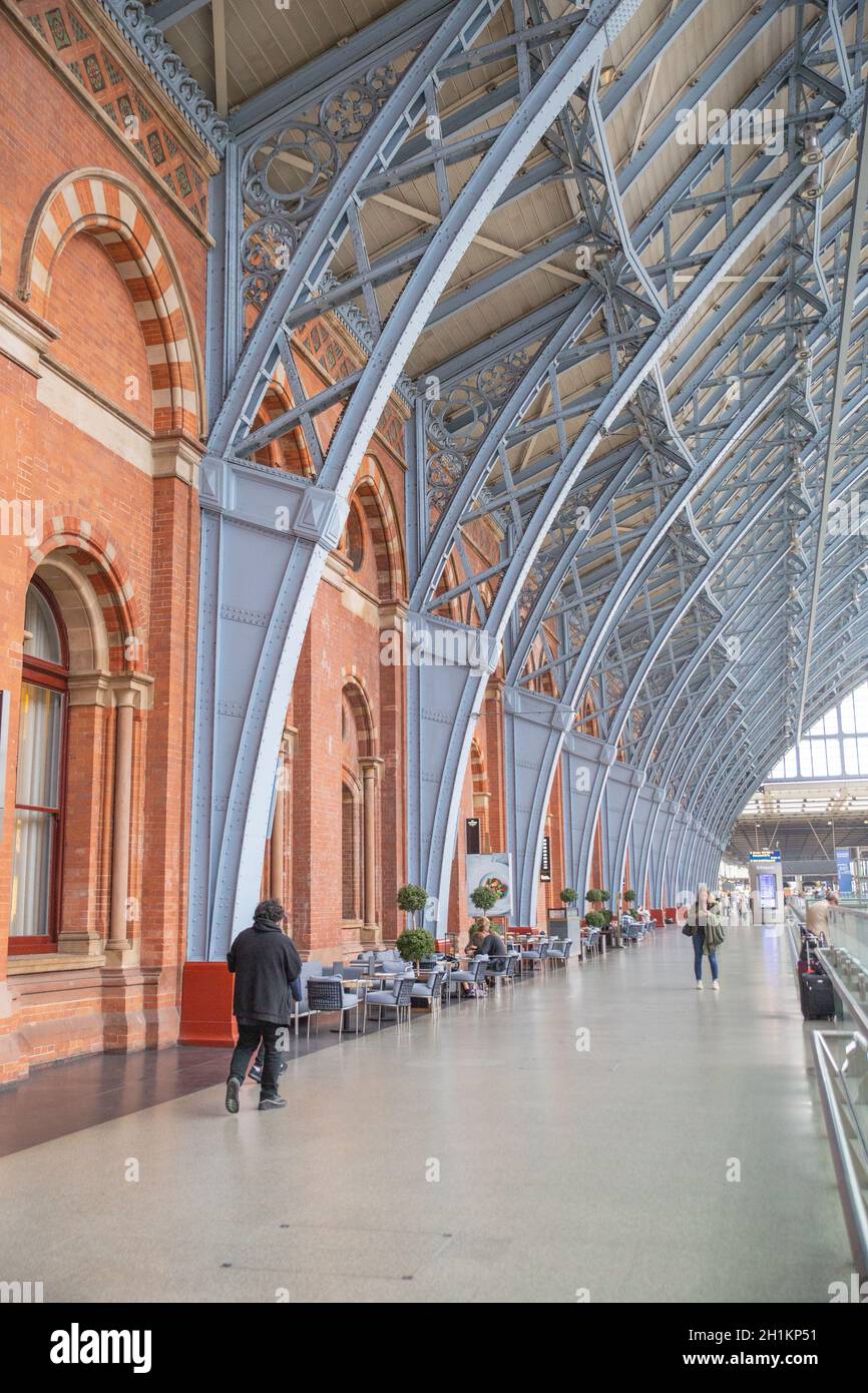 Londra, UK - 30 settembre 2020: Ritratto Vista delle persone su un corridoio sotto i Gray Metal Arches all'interno della stazione ferroviaria di St Pancras da Londra, Foto Stock