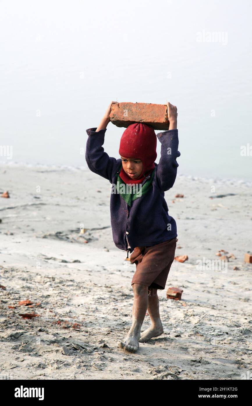 I lavoratori minorili trasportano mattoni che la trasportano sulla sua testa a Sonakhali, Bengala Occidentale, India Foto Stock