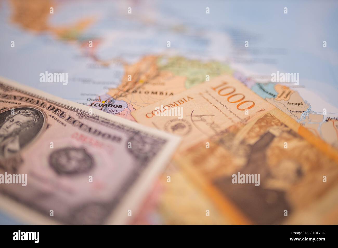 Primo piano di una banconota da cinque sucche - con le parole Centro dell'Ecuador in spagnolo - accanto ad una banconota da 1000 pesos colombiani, entrambe al di sotto dell'Ecuador Foto Stock