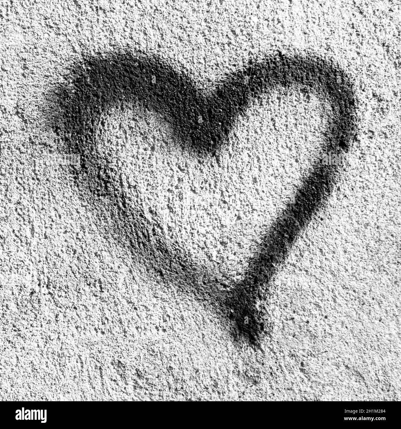 Cuore nero su parete grugnosa. Simbolo del cuore nero dipinto su una parete rustica. Ideale per il concetto di San Valentino. Foto Stock