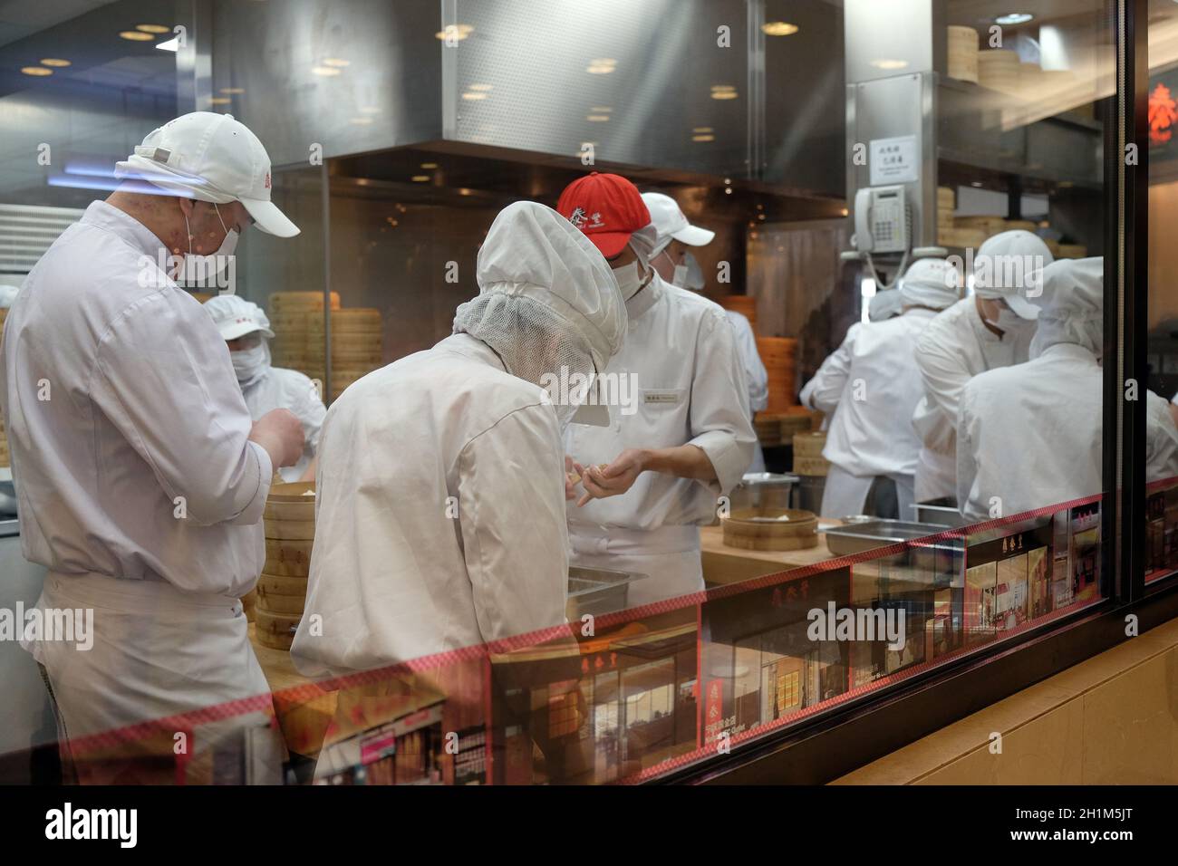Gli chef preparano il cibo nel ristorante del centro commerciale di Shanghai, Cina Foto Stock