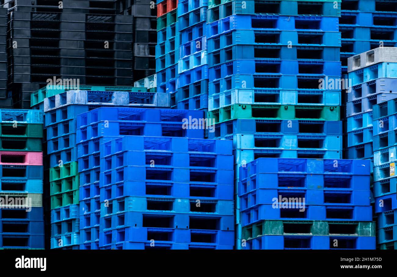 Pila di pallet di spedizione in plastica. Pallet in plastica industriale impilato presso il magazzino di fabbrica. Concetto di carico e trasporto. Rack pallet in plastica per esportazione de Foto Stock