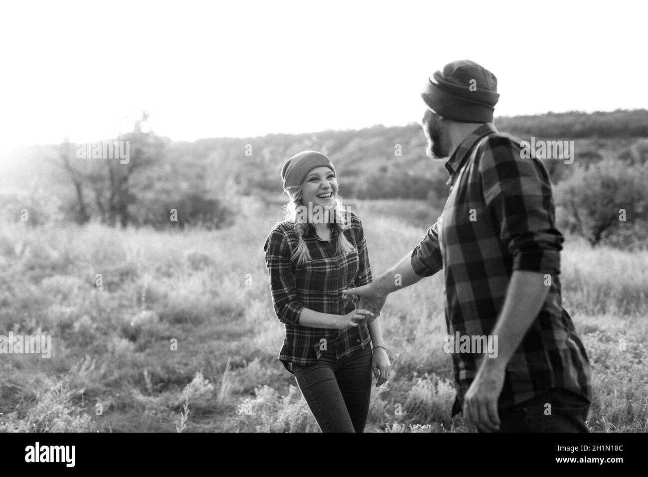 Ragazzo allegro e ragazza su una passeggiata in maglia brillante cappelli e camicie plaid Foto Stock