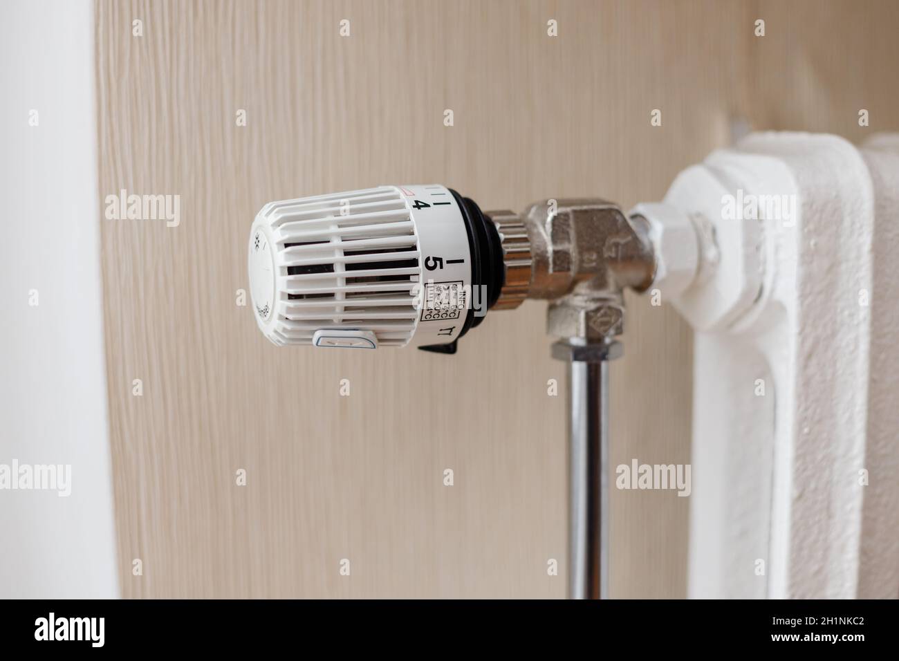 Il termostato sul radiatore di riscaldamento in ghisa regola la temperatura. Foto Stock