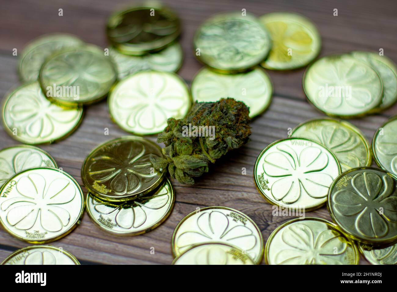 Un Nugget Cannabis colorato circondato da una pila di San Monete d'oro del giorno dei Patty Foto Stock