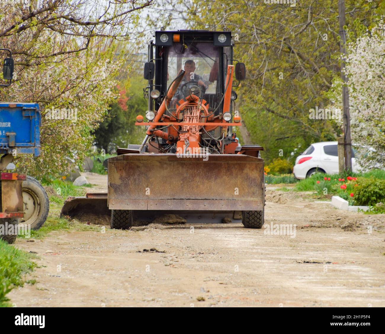 Krasnodar, Russia - 19 aprile 2018: Livellatrice su una strada sterrata. Riparazione stradale con aggiunta di macerie. Foto Stock