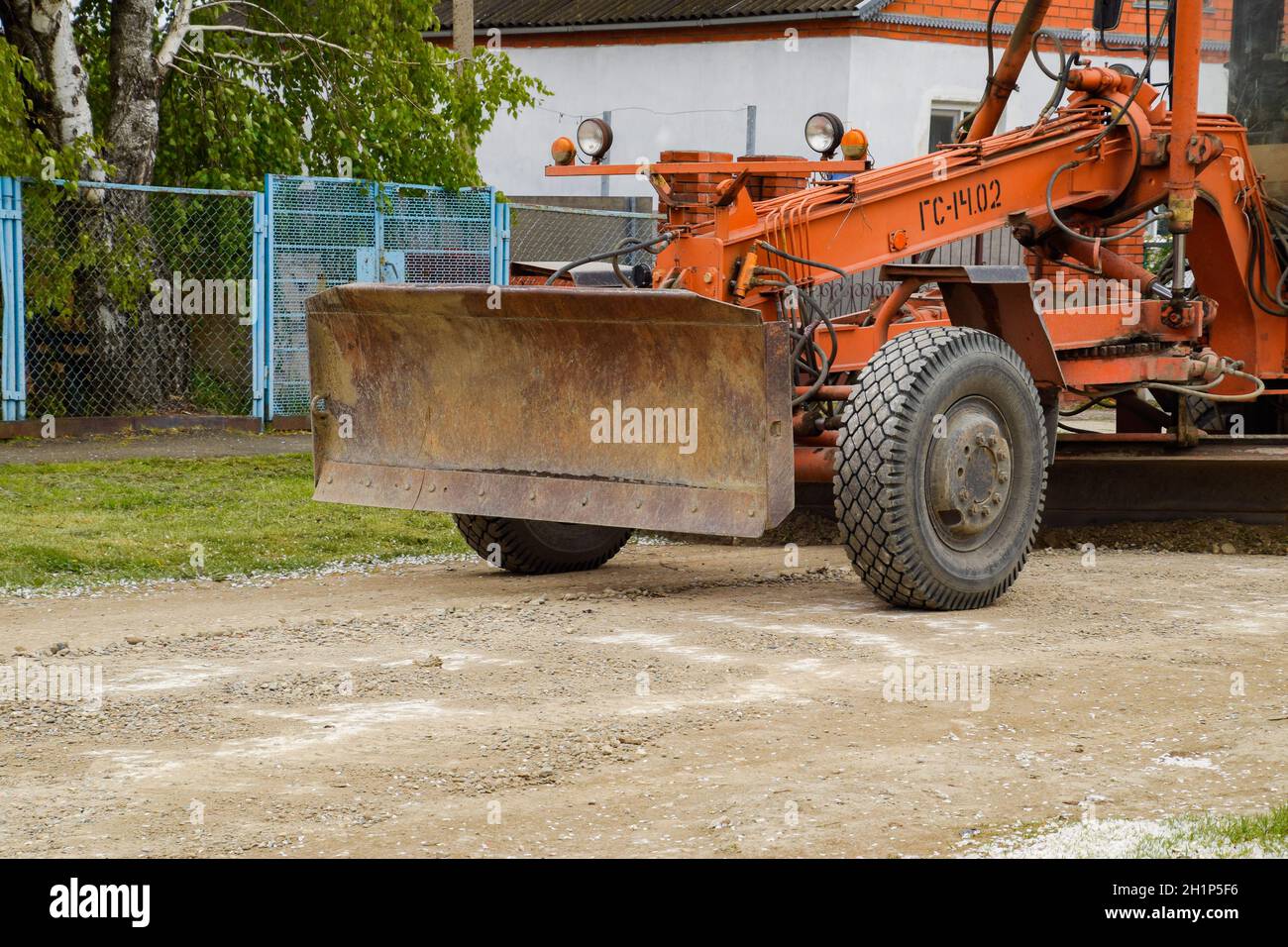 Krasnodar, Russia - 19 aprile 2018: Livellatrice su una strada sterrata. Riparazione stradale con aggiunta di macerie. Foto Stock