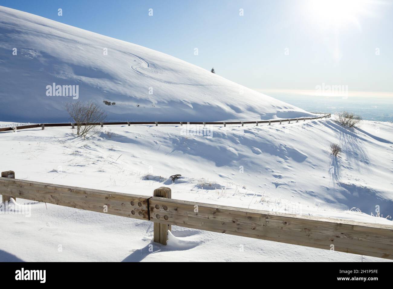 Paesaggio invernale, strada curva con neve. Paesaggio del Monte Grappa, Italia Foto Stock