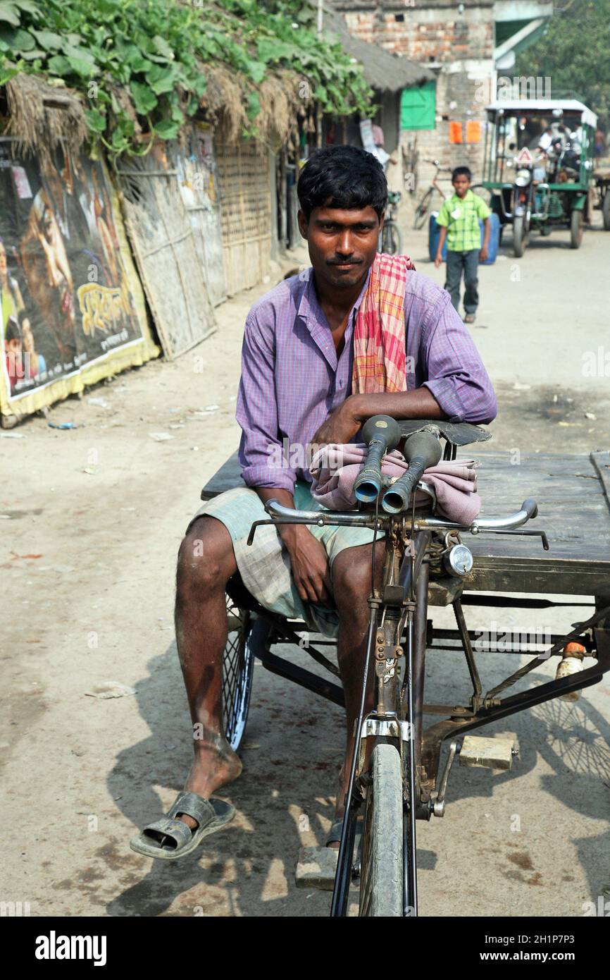 In rickshaw driver attende il prossimo cliente in Baruipur, West Bengal, India Foto Stock