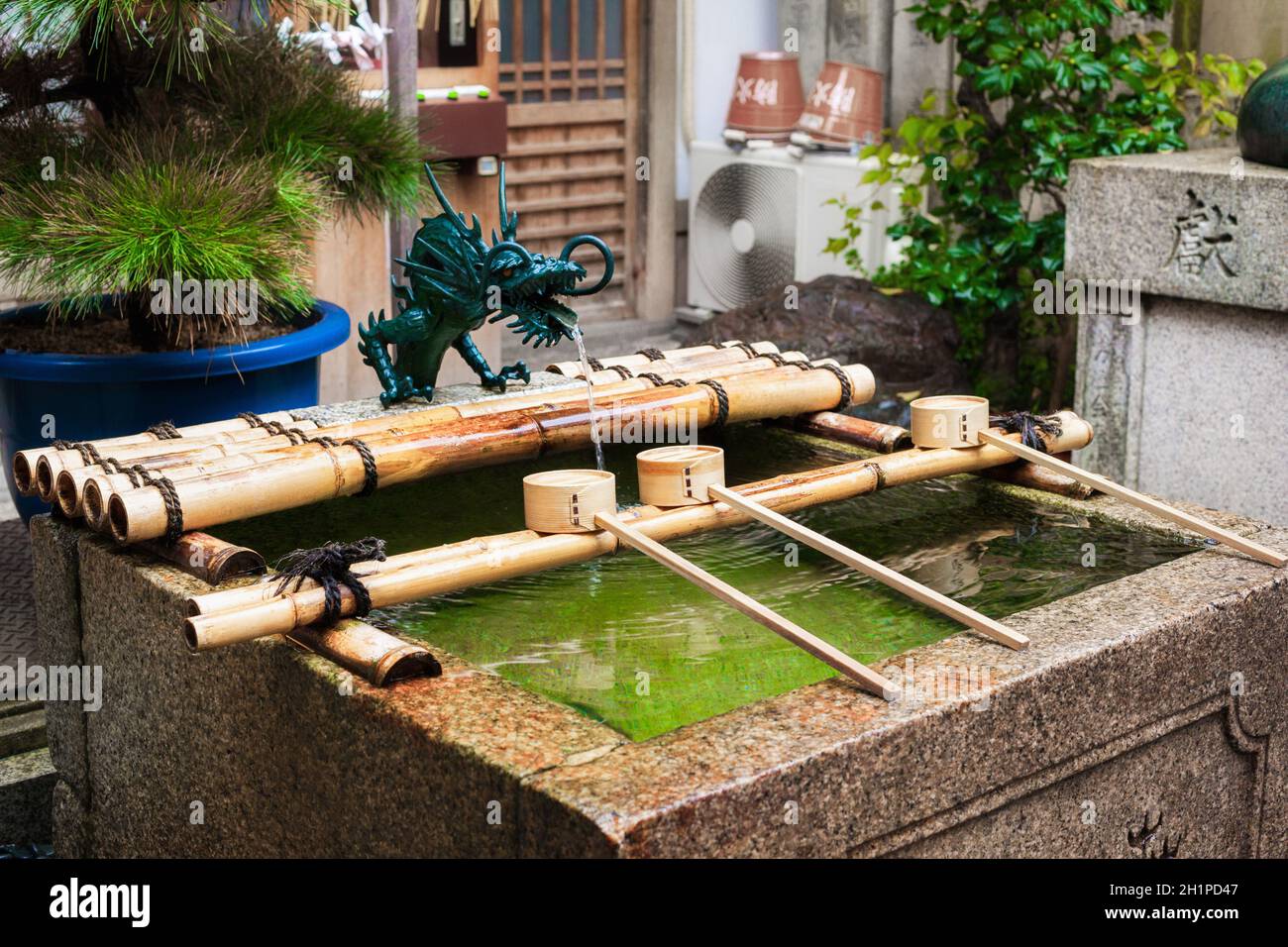 Padiglione per le abluzioni d'acqua per una purificazione cerimoniale al Santuario di Nishiki Tenmangu, Kyoto, Giappone. L'acqua naturale della sorgente fluisce dal sottosuolo. Foto Stock