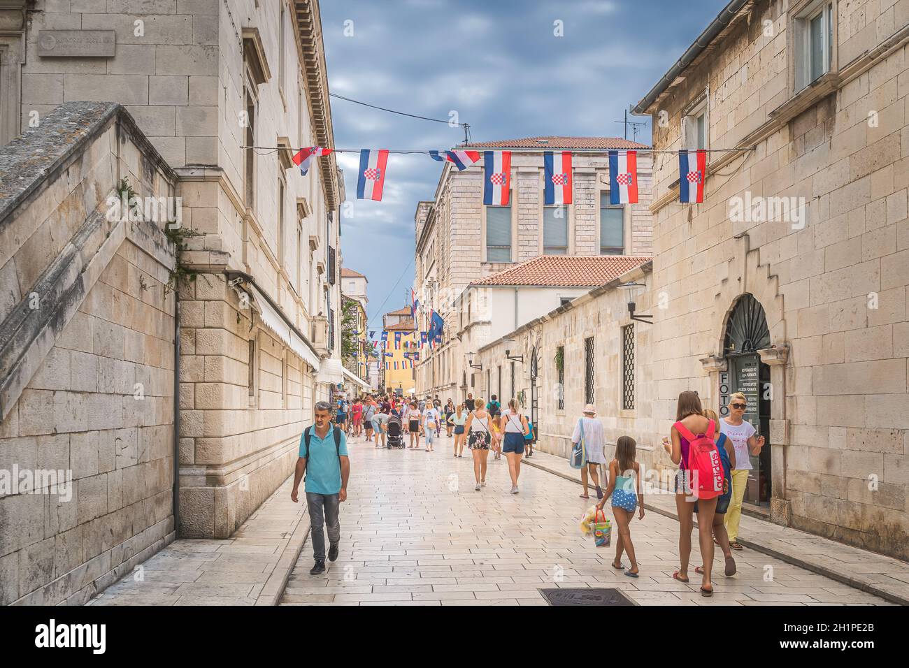 Zadar, Croazia, luglio 2019 turisti in visita alle belle e strette strade della città vecchia di Zaton con l'antica, antica architettura romanica Foto Stock