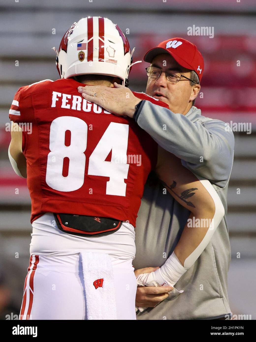 Madison, WISCONSIN, Stati Uniti. 16 ottobre 2021. Paul Chryst, allenatore di badgers del Wisconsin, abbraccia Tight End Jake Ferguson (84) durante il pre-partita nella partita di football NCAA tra i Cavalieri neri dell'esercito e i badgers del Wisconsin al Camp Randall Stadium di Madison, WISCONSIN. Darren Lee/CSM/Alamy Live News Foto Stock