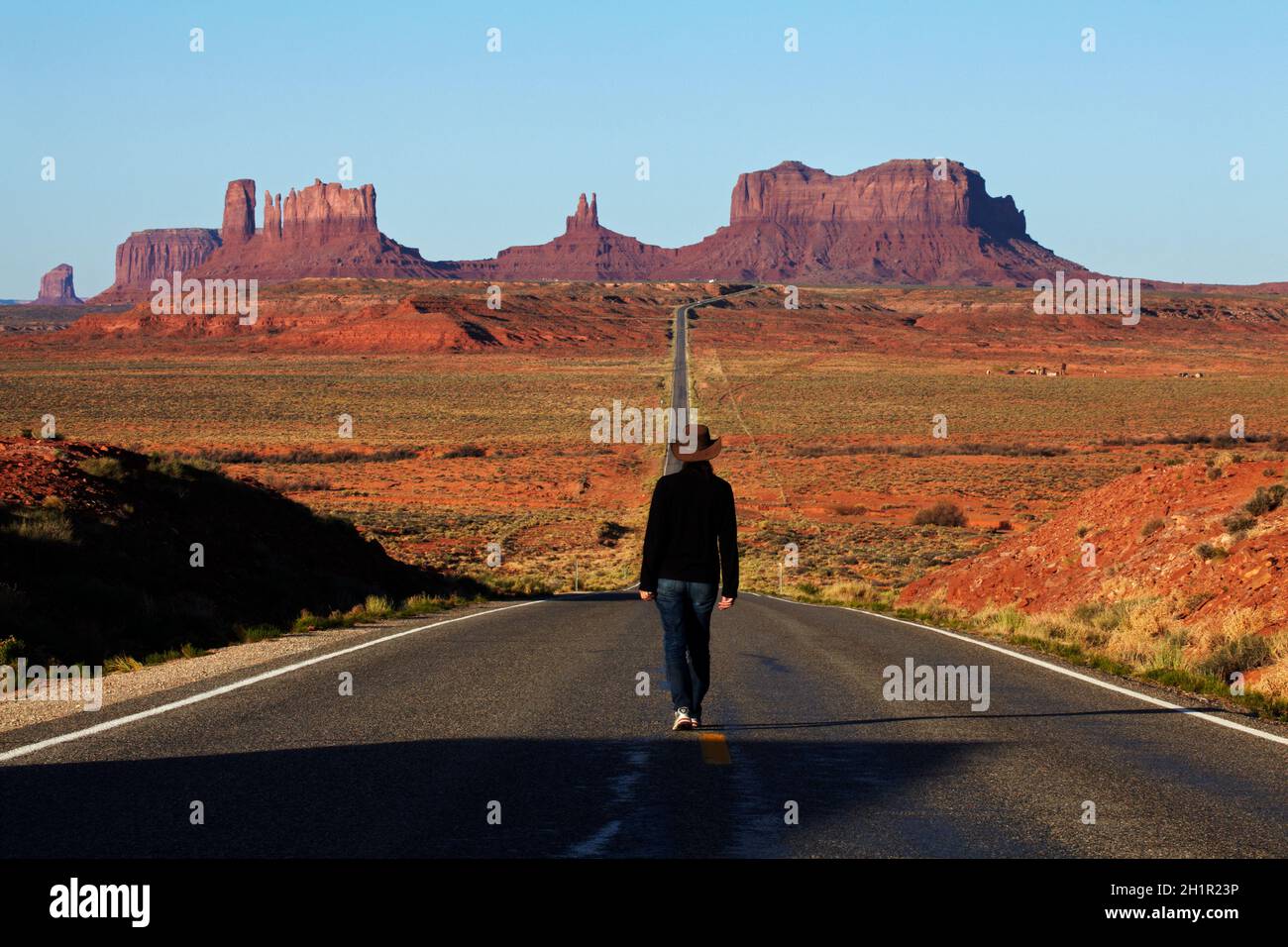 Donna che cammina sulla U.S. Route 163 verso Monument Valley, Navajo Nation, Utah, vicino al confine con l'Arizona, USA (modello rilasciato) Foto Stock