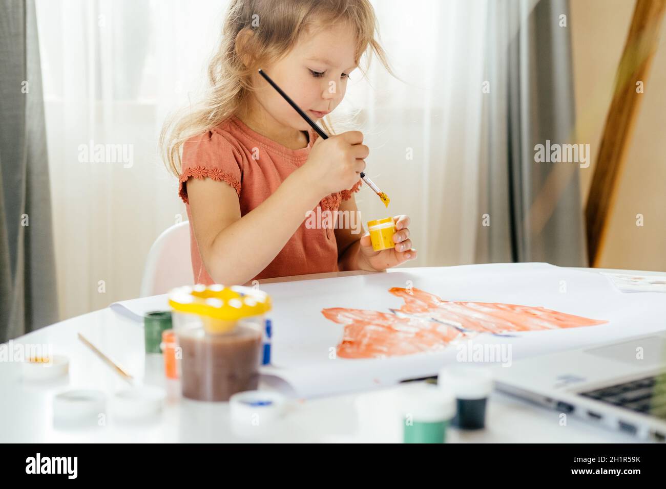 La ragazza che trascorre un po' di tempo a disegnare l'immagine utilizzando un computer portatile a casa. Apprendimento a distanza, formazione online. Foto Stock