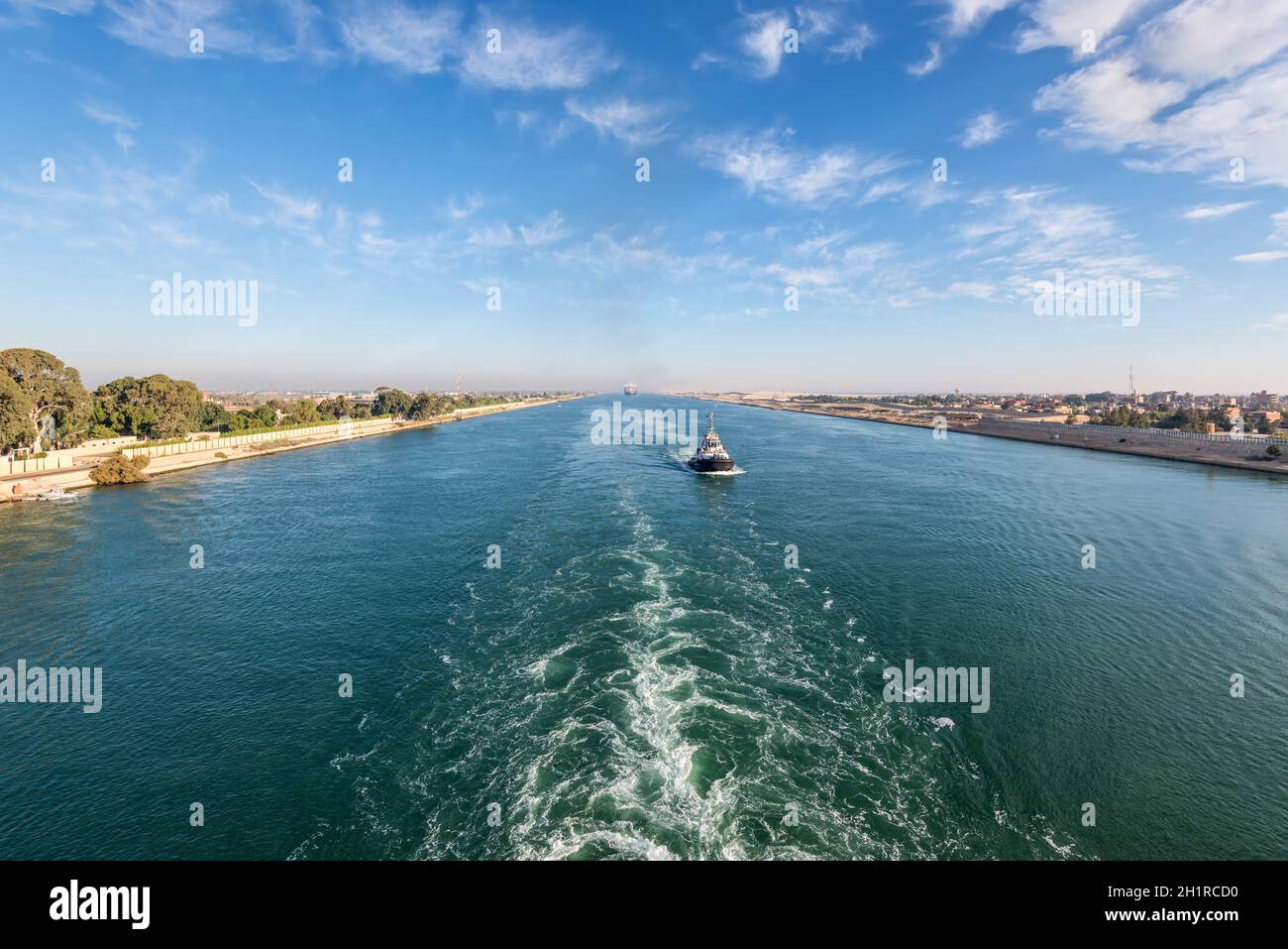 Nave che passa attraverso il canale di Suez in Egitto. Il rimorchiatore accompagna le navi. Foto Stock